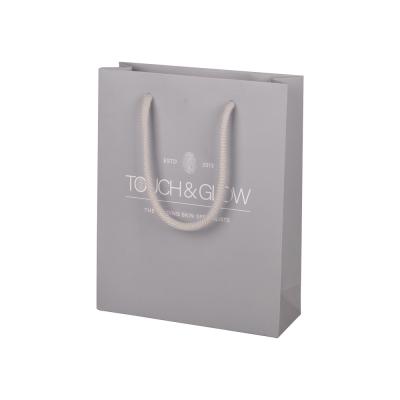 China Impresión offset Bolsas de papel regalo gris Embalaje de compras con mango de cuerda de algodón en venta