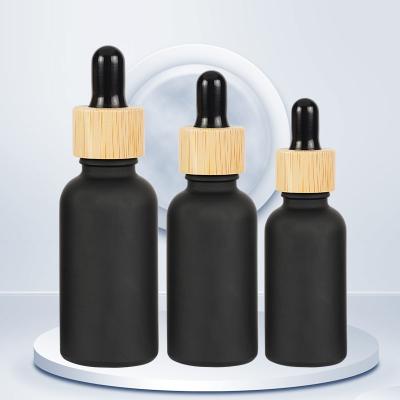 China 5ml 10ml 15ml Matte Black Glass Dropper Bottles With Bamboo Lid for sale