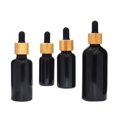 China Black Glass Serum Dropper Bottle With Bamboo Lid 1oz 2oz 4oz for sale